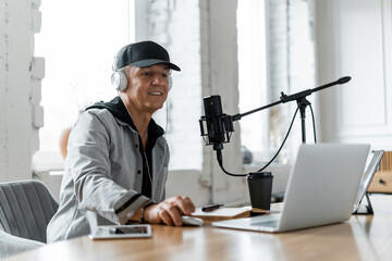 The radio host transmits the news and speaks into the microphone. A freelancer puts on music for...