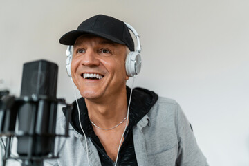 The radio host transmits the news and speaks into the microphone. A man's favorite job. A freelancer puts on music for listeners. This person works in a radio studio.