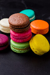 Colorful macarons cookies on the black background