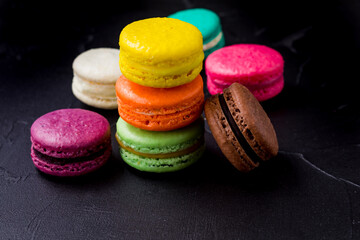 Colorful macarons cookies on the black background