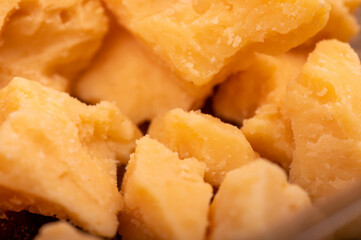 Slices of crushed parmesan cheese, close-up selective focus.