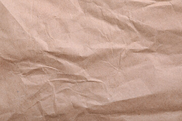 Texture of wrinkled kraft paper bag as background, closeup