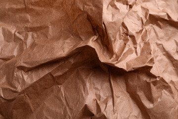 Texture of wrinkled kraft paper bag as background, closeup