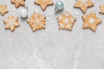 Tasty Christmas cookies and baubles on light grey marble table, flat lay. Space for text