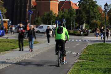 Młodzy mężczyzna jedzie na rowerze po ścieżce rowerowej we Wrocławiu.	 - obrazy, fototapety, plakaty