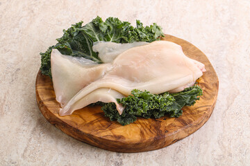 Raw squid over wooden board