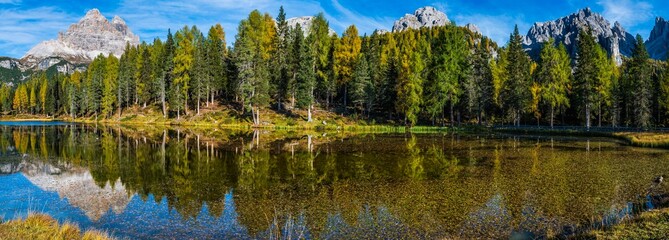 Fototapeta premium Autumn colors on the lake of Antorno. Magical glimpses of the Dolomites. Three peaks of Lavaredo