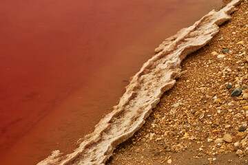 Reddish edge of a salt lake crusted with salt