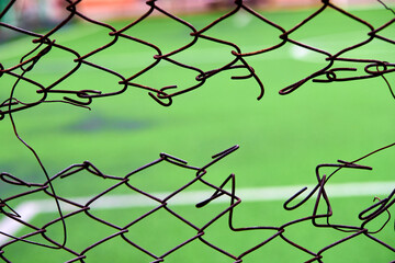 mesh netting torn is hold in the center of mesh fence