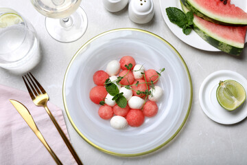 Delicious salad with watermelon balls, herbs and mozzarella cheese served on light table, flat lay
