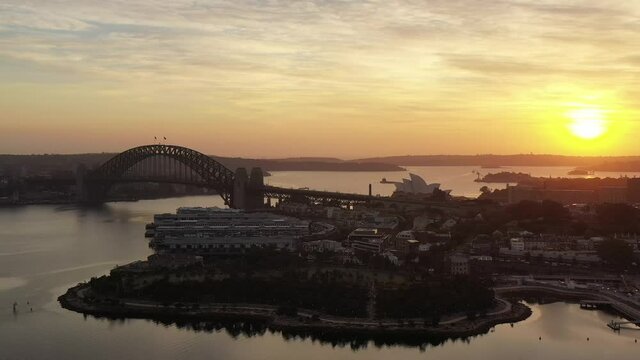 Sunrise over Sydney city skyline across Harbour in aerial panorama as 4k.
