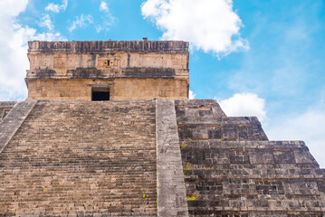 Ancient ruins of Temple of Kukulkan, pyramid in Chichen Itza against cloudy sky. Historic architectural ruins of mayan