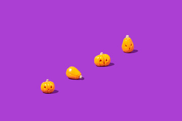 Pattern made of pumpkins on a purple background. Minimalistic Halloween concept. Creative idea.