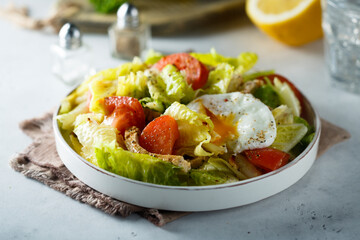 Healthy green salad with chicken and poached egg