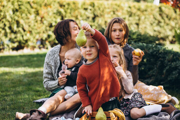 Mother with four kids having picnic on back yard