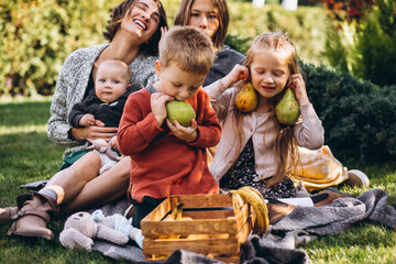Mother with four kids having picnic on back yard