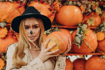 Woman with halloween make up standing by halloween pumpkins