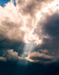 Fototapeta na wymiar Sunbeams breaking through the dark clouds. Only sky, no land.