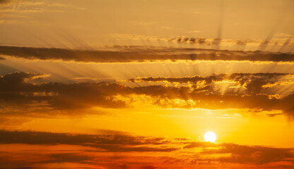 Sunbeams breaking through the dark clouds at sunset. Only sky, no land.