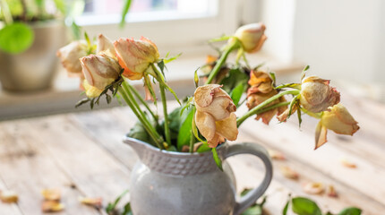 Blumenstrauss aus vertrockneten Rosen in Keramik Krug