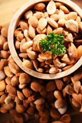Bowl of apricot kernels on wooden table