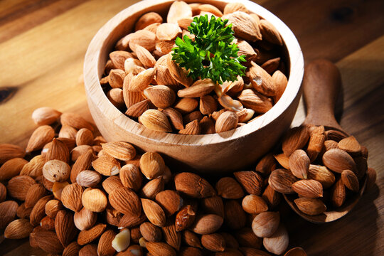 Bowl of apricot kernels on wooden table