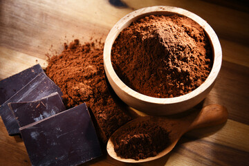 Composition with bowl of cocoa powder on wooden table