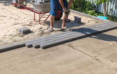 A worker lays paving slabs