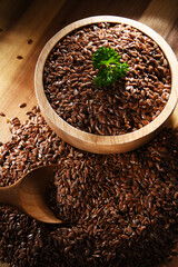 Bowl of brown flax seeds on wooden table