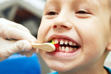 Fototapeta premium little boy brushing teeth with toothbrush closeup mouth