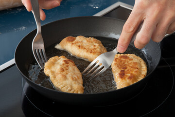 fry tuna patties in a pan. freír las empanadas de atún en una sartén. - obrazy, fototapety, plakaty
