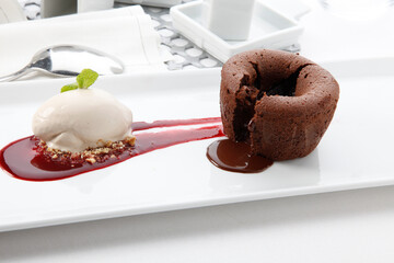 Pastel de chocolate, bomba con chocolate y salsa de frambuesa y helado de nata.  chocolate bomb