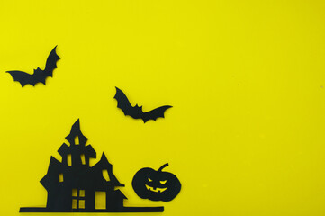 Halloween and decoration concept - bats, pumpkins, gloomy paper house, gloomy black tree branches on a yellow background. Folded paper origami art.
Halloween background with cut out
bats and other dec