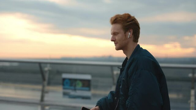 Man using earphones and mobile for listening music outdoors