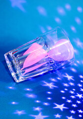two pink menstrual cups in a glass cup on a blue background background with stars photo