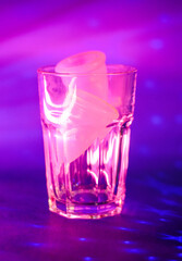 two pink menstrual cups in a glass cup on a purple background background photo