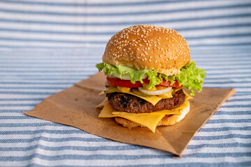 Burger with juicy meat cutlet, herbs and vegetables. Sea stule