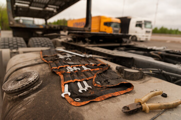 A set of repair tools is on the truck's gas tank.