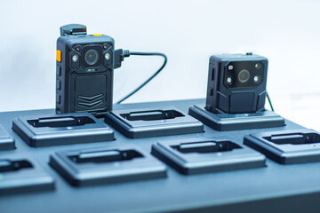 Portable video recorders on a white background. They are installed at charging station. Concept - selling a video recording system. Outer video recorders in close-up. Portable DVR devices.