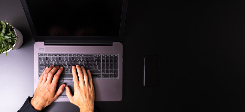 Person Using A Laptop Computer On A Solid Color Background