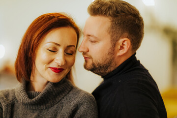 Couple in love photographed in a modern decorated Christmas-themed studio. Non-commercial appearance and neutral colors