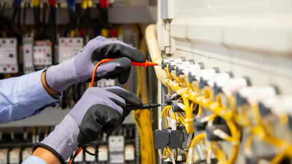 Electrical engineer using digital multi-meter measuring equipment to checking electric current...