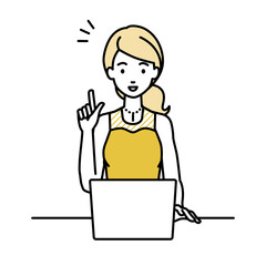 デスクで座ってPCを開いて何かひらめいたドレスの女性