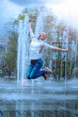 The fountain. City fountain. The girl plays in the fountain. Leap of the girl in the fountain. Dry fountain.