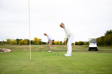 Portrait of an active senior woman playing golf at the golf course and enjoying free time outdoors.