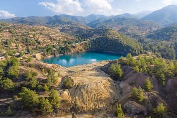 Abandoned pyrite mine in Xyliatos, Cyprus. Lake in open mine pit and waste heaps over mountains...