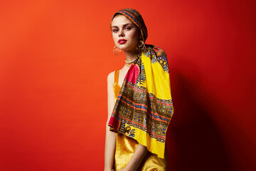 beautiful woman in multicolored turban attractive look Jewelry red background