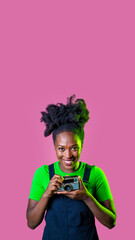 Fototapeta na wymiar Young black woman isolated pink background holding vintage camera smiling happy - cropped advertising copyspace