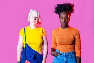 Two young diverse multicultural caucasian and black women best friends posing isolated background