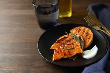 Concept of tasty eating with baked pumpkin on wooden background